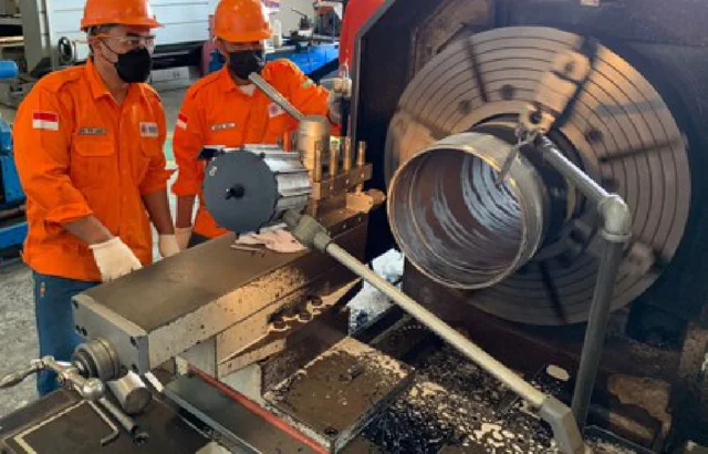 NMS workshop personnel operating casing-threading equipment