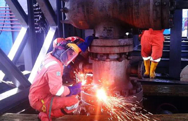NMS field crew welding at a wellhead